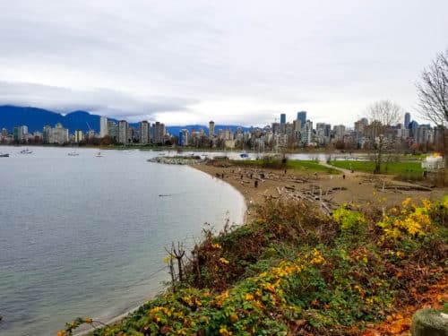 A distant view of a beach with the city of vancouver skyline in the background