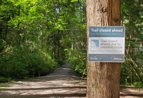 A picture of a park sign warning of trail closures due to unstable slopes at hastings creek park (off-leash trails), north vancouver, bc